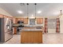Well-lit kitchen with wood cabinets, stainless appliances, a functional island, and tile flooring at 4826 W Ardmore Rd, Laveen, AZ 85339