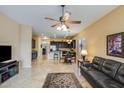 Open-concept living room featuring tile flooring, a ceiling fan, and seamless flow into the dining and kitchen areas at 5014 E Kirkland Rd, Phoenix, AZ 85054