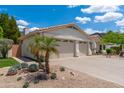 Wide angle of a home with desert landscaping, a three-car garage, and a tile roof on a sunny day at 5510 W Arrowhead Lakes Dr, Glendale, AZ 85308