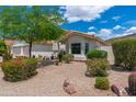 Landscaped front yard featuring colorful bushes, rocks, cacti, and a healthy green tree against a sunny sky at 5510 W Arrowhead Lakes Dr, Glendale, AZ 85308