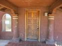 Covered porch showcasing a carved wood front door, tile flooring, and decorative columns at 5716 E Desert Vista Trl, Cave Creek, AZ 85331