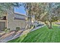 Attractive exterior view of a townhouse with mature trees, green grass, and manicured landscaping at 602 N May -- # 23, Mesa, AZ 85201