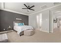 Comfortable bedroom featuring soft carpet, a stylish ceiling fan and gray accent wall at 6931 W Spur Dr, Peoria, AZ 85383