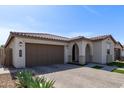 Beautiful single-story home showcasing desert landscaping, a tile roof, and an attached two-car garage at 6931 W Spur Dr, Peoria, AZ 85383