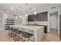 A modern kitchen features an island with barstool seating and stylish pendant lighting above at 6931 W Spur Dr, Peoria, AZ 85383