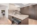 Modern kitchen island with stone countertop, seating, wood accent wall, and modern cabinets at 7137 E Rancho Vista Dr # 4011, Scottsdale, AZ 85251