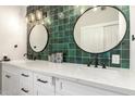 Modern bathroom with a dual vanity, striking green tile backsplash, and stylish fixtures, creating a spa-like ambiance at 736 S Winthrop Cir, Mesa, AZ 85204