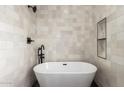 Elegant bathroom featuring a freestanding tub, sleek black fixtures, and minimalist design for a serene bathing experience at 736 S Winthrop Cir, Mesa, AZ 85204