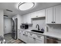 Well-lit kitchen featuring stainless steel appliances, modern white cabinets, and a sleek black sink at 7808 E Valley Vista Dr, Scottsdale, AZ 85250