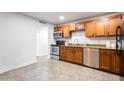 Clean updated kitchen boasts stainless steel appliances, granite countertops, and tile floors at 8021 W Hazelwood St, Phoenix, AZ 85033