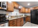Updated kitchen features stainless steel appliances, granite countertops, and rich wood cabinetry at 8021 W Hazelwood St, Phoenix, AZ 85033