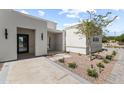 Inviting front entrance with stone pathway, desert landscaping, and a modern glass door at 9611 E Clinton St, Scottsdale, AZ 85260