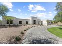Spacious front yard with a paver driveway and desert landscaping leading to the modern home at 9611 E Clinton St, Scottsdale, AZ 85260