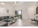 Bright living room with tile floors, sliding glass doors to the patio, and a modern gray leather couch at 10136 E Southern Ave # 3091, Mesa, AZ 85209