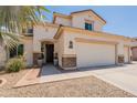 Charming two-story home with three-car garage, desert landscaping, and covered entryway at 11003 E Ravenna Cir, Mesa, AZ 85212