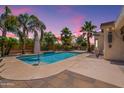 Inviting backyard pool with lush landscaping, swaying palm trees, and string lights at 11003 E Ravenna Cir, Mesa, AZ 85212