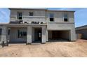 Unfinished two-story home with covered entry, a two-car garage, and visible construction materials at 11444 E Utopia Ave, Mesa, AZ 85212