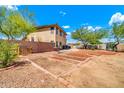 Large backyard featuring garden beds, block wall, and desert landscaping under a bright sky at 12709 N El Frio St, El Mirage, AZ 85335