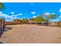 Large backyard features gravel, block wall, and desert landscaping under a bright sky at 12709 N El Frio St, El Mirage, AZ 85335