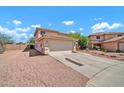 Side view of a two-story home boasting a two-car garage, desert landscaping, and a long driveway at 12709 N El Frio St, El Mirage, AZ 85335