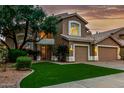 Charming two-story home featuring a well-manicured lawn and an attached three-car garage at 13566 N 93Rd Pl, Scottsdale, AZ 85260