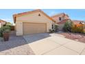 Beautiful front yard view featuring a two-car garage and a well-maintained concrete driveway at 13584 N 102Nd Pl, Scottsdale, AZ 85260