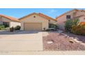 Cozy home featuring desert landscaping, a two-car garage, and a well-manicured lawn at 13584 N 102Nd Pl, Scottsdale, AZ 85260