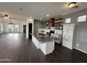 Bright, open kitchen featuring a stainless steel island, modern appliances, white cabinets, and wooden shelving at 1492 S Pike Ln, Gilbert, AZ 85296