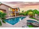 Luxury home backyard featuring a large pool, hot tub, mature landscaping and second story balcony at 15237 S 19Th Way, Phoenix, AZ 85048