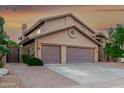 A three-car garage home with desert landscaping and a brick paver driveway at 15237 S 19Th Way, Phoenix, AZ 85048
