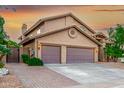 Home with a two-car garage, brick driveway, and desert landscaping on a beautiful day at 15237 S 19Th Way, Phoenix, AZ 85048