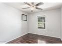 Bedroom with dark wood laminate flooring, ceiling fan, and a window at 17235 W Statler St, Surprise, AZ 85388