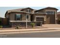Single story house featuring brick driveway, stone accents, and a private gated entrance at 17427 W Hadley St, Goodyear, AZ 85338