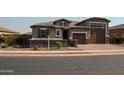 Inviting single-level home with brick driveway, stone accents, and neatly landscaped front yard at 17427 W Hadley St, Goodyear, AZ 85338