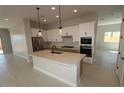 Modern kitchen with white cabinets, stainless steel appliances, and a large center island at 19321 W Luke Ave, Litchfield Park, AZ 85340