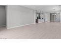 Open-concept living room with light tile flooring that seamlessly connects the living space to the kitchen and dining area at 19321 W Luke Ave, Litchfield Park, AZ 85340
