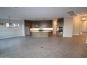 Open-concept living room with tile flooring, recessed lighting, and a modern kitchen at 32541 N 135Th Dr, Peoria, AZ 85383