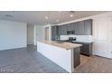 Well-lit kitchen with stainless steel appliances and white backsplash at 39980 W Bunker Dr, Maricopa, AZ 85138