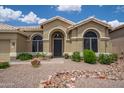 Welcoming single-story home featuring arched windows, desert landscaping, and a cozy front entrance at 6388 W Donald Dr, Glendale, AZ 85310