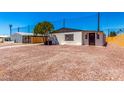 Charming home featuring a low maintenance yard, complemented by desert landscaping and mature shade tree at 7442 E Baseline Rd, Mesa, AZ 85209