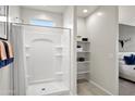 Bright bathroom with a white shower, storage shelves, and view to the bedroom at 9943 S Desert View Dr, Apache Junction, AZ 85120