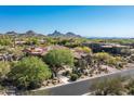 An aerial shot of a stunning desert home with a tile roof and beautiful desert landscaping at 10531 E Cinder Cone Trl, Scottsdale, AZ 85262