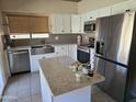 Bright kitchen features white cabinetry, stainless steel appliances, and an island, blending style and functionality at 11106 E Clinton St, Scottsdale, AZ 85259