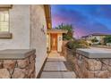 Inviting walkway with decorative stone columns leads to the beautiful wooden front door at 12451 W Nadine Way, Peoria, AZ 85383