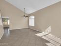 Spacious living room with tile flooring, high ceilings, neutral paint, a ceiling fan, and abundant natural light at 13620 N 82Nd Ln, Peoria, AZ 85381