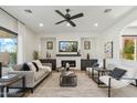 Bright living room featuring a fireplace, dark wood accents, neutral furniture, and indoor plants at 15711 S 11Th Ave, Phoenix, AZ 85045