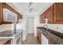 Kitchen features granite counters, white appliances, and wood cabinets for a charming feel at 1634 E Donner Dr, Tempe, AZ 85282