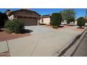 Inviting home exterior featuring a tidy lawn, desert landscaping, and a private driveway at 17516 W Pershing St, Surprise, AZ 85388