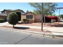 A cozy house exterior with stone accents and vibrant bougainvillea bushes, nestled on a corner lot at 17516 W Pershing St, Surprise, AZ 85388