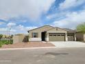 Charming single-story home featuring a tan stucco exterior, two-car garage, and low maintenance front yard at 20795 N Roadrunner Ln, Maricopa, AZ 85138